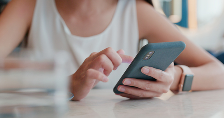 Woman use of mobile phone in coffee shopの写真素材