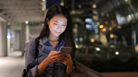 Asian woman sms texting using app on smart phoneの写真素材
