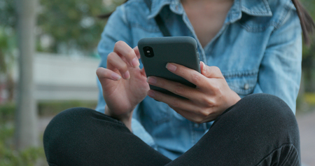 Woman using mobile phone with blur backgroundの写真素材