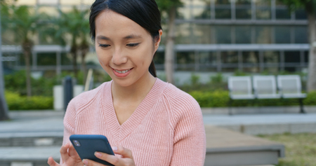 Young woman using mobile phone at outdoorの写真素材