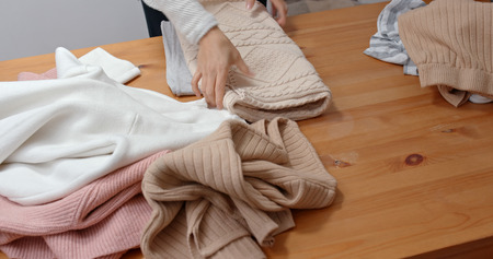 Housewife fold clothes at homeの写真素材