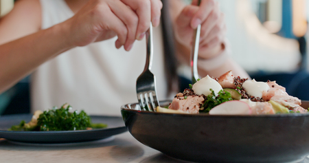 Woman enjoying the salad in restaurantの写真素材