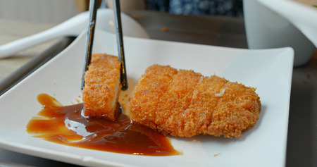 Woman eating tonkatsu in restaurantの写真素材