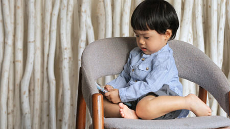 Little boy playing smartphoneの写真素材