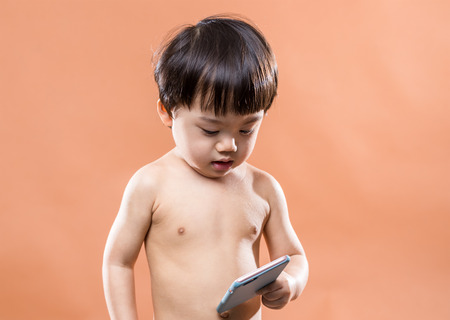 Asian baby boy holding cellphoneの写真素材