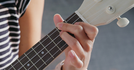 Woman play ukulele at home