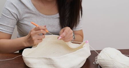 Woman knitter making fabric from threadの写真素材