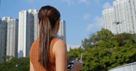 Woman play with flying drone at outdoor