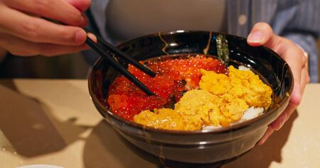 Salmon roe and urchin sashimi rice bowl in restaurant