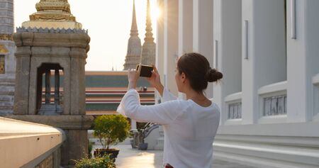 Woman go travel and take photo on cellphone at bangkok