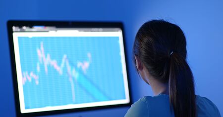 Woman study on stock market data at night