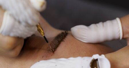 Microblading procedure, master work on woman eyebrow