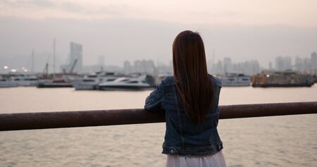 Woman look at the sunset sea viewの写真素材