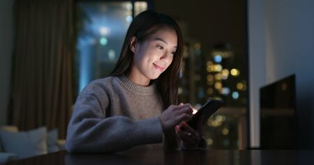 Woman use of cellphone at homeの写真素材