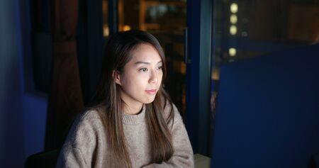 Woman use of computer at nightの写真素材