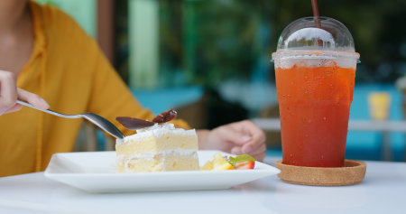 Woman eat cake in coffee shopの写真素材