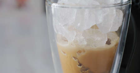 Coffee from machine to the ice in glassの写真素材
