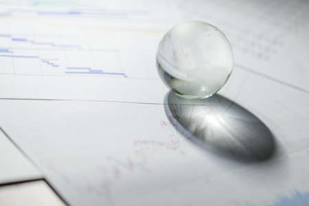 Glass of globe with stock market chart