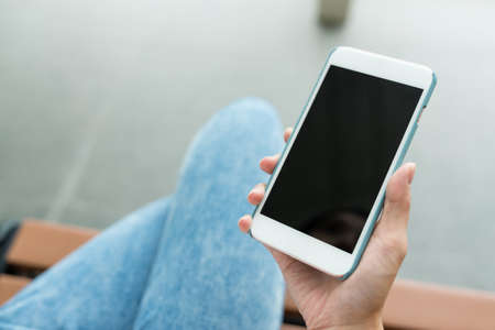 Woman holding cellphone with blank screenの写真素材