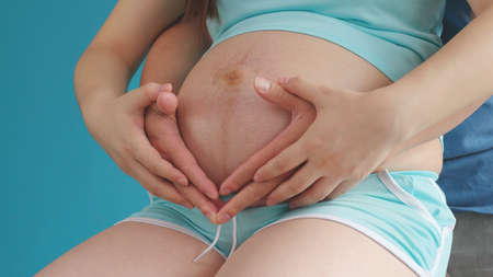 Couple touching on pregnant woman belly togetherの写真素材