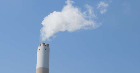 Smoke from factory over blue skyの写真素材