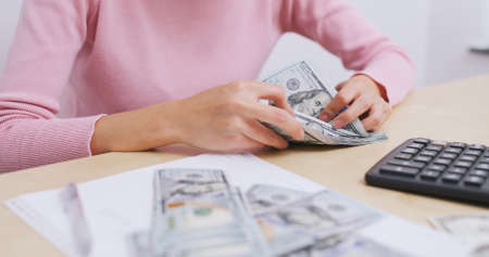 Woman counting the money at homeの写真素材