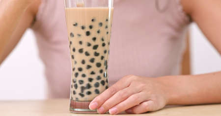 Woman drinking Glass of Taiwan Bubble milk teaの写真素材