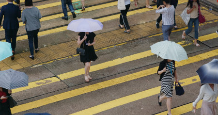 Central, Hong Kong - People cross the road at rain dayの写真素材