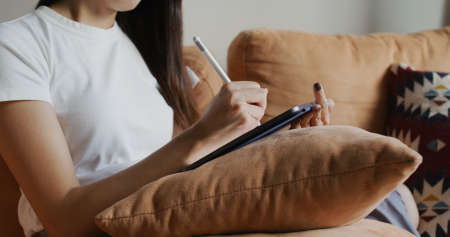 Woman draw on tablet computer at homeの写真素材