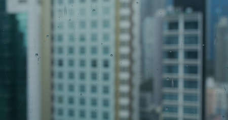 Rain drop on window glass with office tower backgroundの写真素材