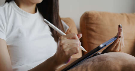 Woman draw on tablet computer at homeの写真素材