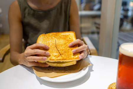 Woman eat roast toast in restaurantの写真素材