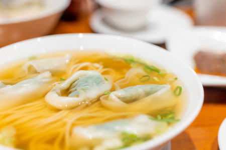 Meat and vegetable dumpling noodles soup bowl in restaurantの写真素材