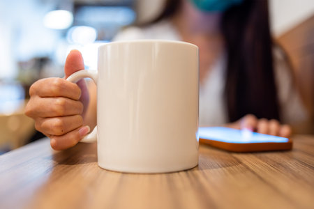 Woman drink of coffee and use mobile phoneの写真素材