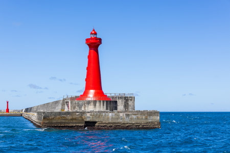 Red lighthouse over the concrete pier in Hualien harbor of Taiwanの写真素材