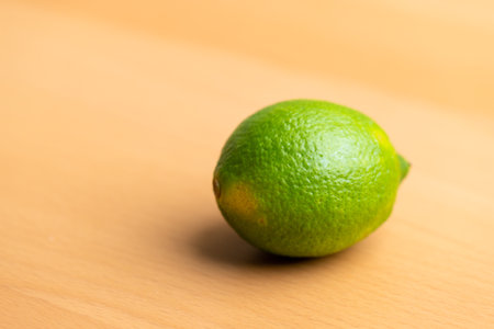 Whole fresh green lemon on table