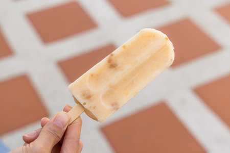 Taking a lick of a fruity ice popの写真素材