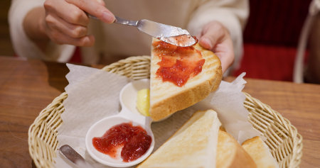 Strawberry jam spread on toast in coffee shop