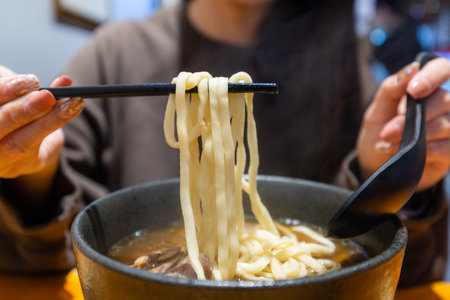 Woman eat Taiwan braised beef noodle soupの写真素材