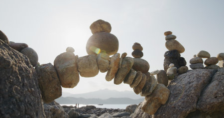 Arch of pebbles in balancing on the sea coastの写真素材