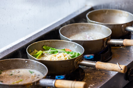 Cooking noodles in the open kitchen in restaurantの写真素材