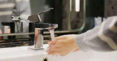 Woman wash her hand in toiletの写真素材