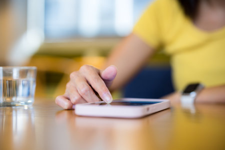 Woman use smart phone and on the table at coffee shopの写真素材