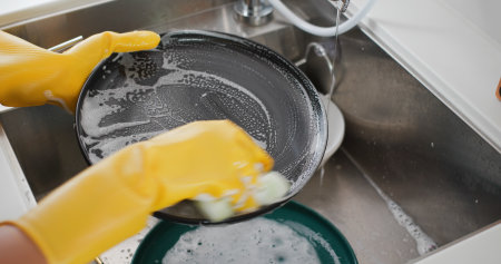 Woman wash dish in kitchenの写真素材