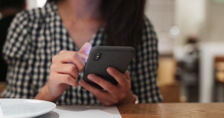 Woman use of mobile phone order in restaurantの写真素材