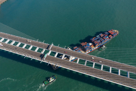 Kwai Tsing, Hong Kong 04 December 2019: Top view of cargo ship pass though suspension bridgeのeditorial素材