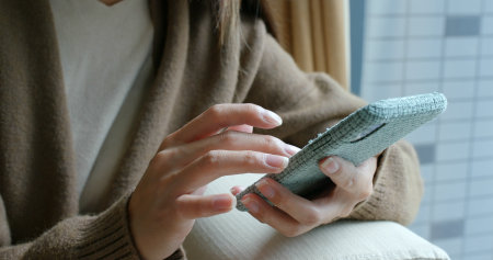 Housewife use of mobile phone at homeの写真素材