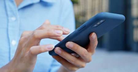 Close up of woman use of smart phone in cityの写真素材