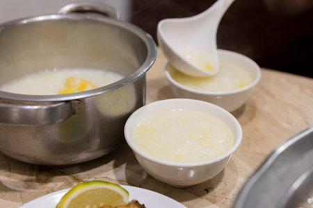 Pour congee into bowl at restaurant