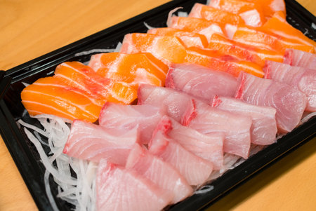 Slice of fresh raw salmon fish on the plastic boxの写真素材